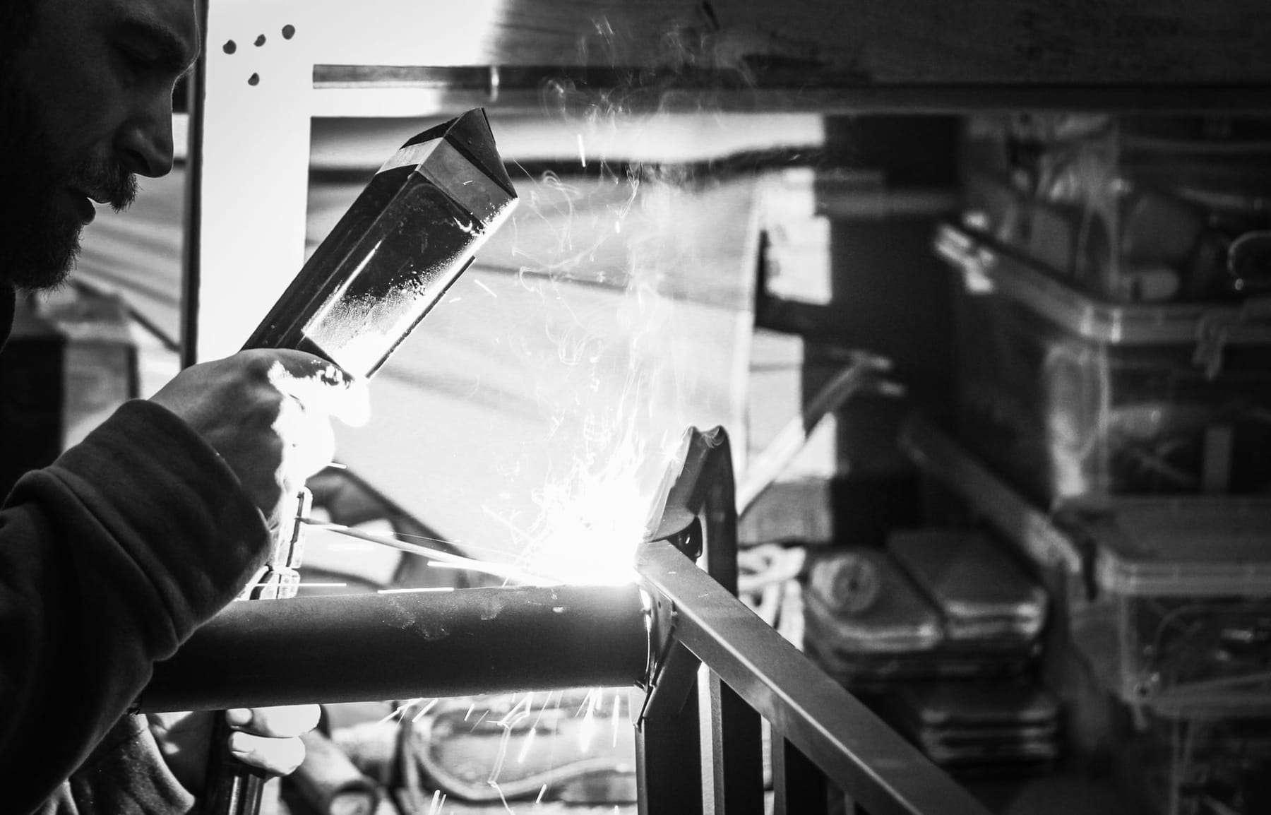 Framebuilder welding a bicycle frame with sparks flying